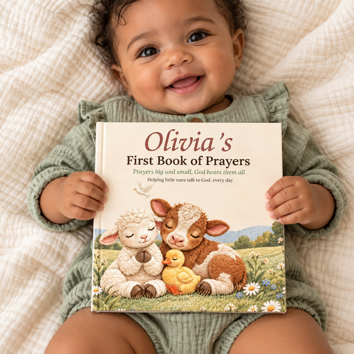 Baby holding a personalized First Book of Prayers